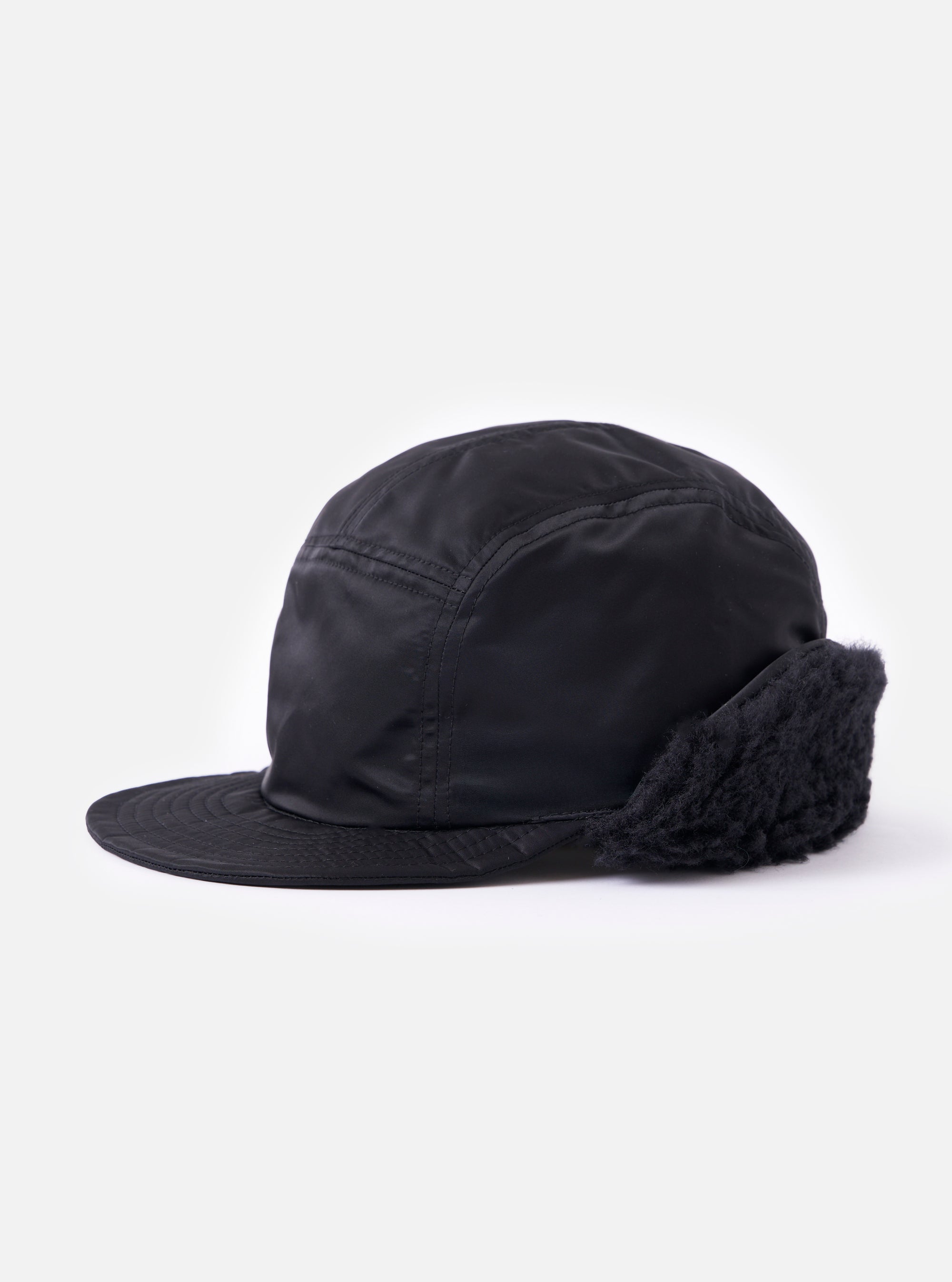Side view of the cableami® Black Military Nylon Twill Cap on a white background. The cap is black nylon with ear flaps.