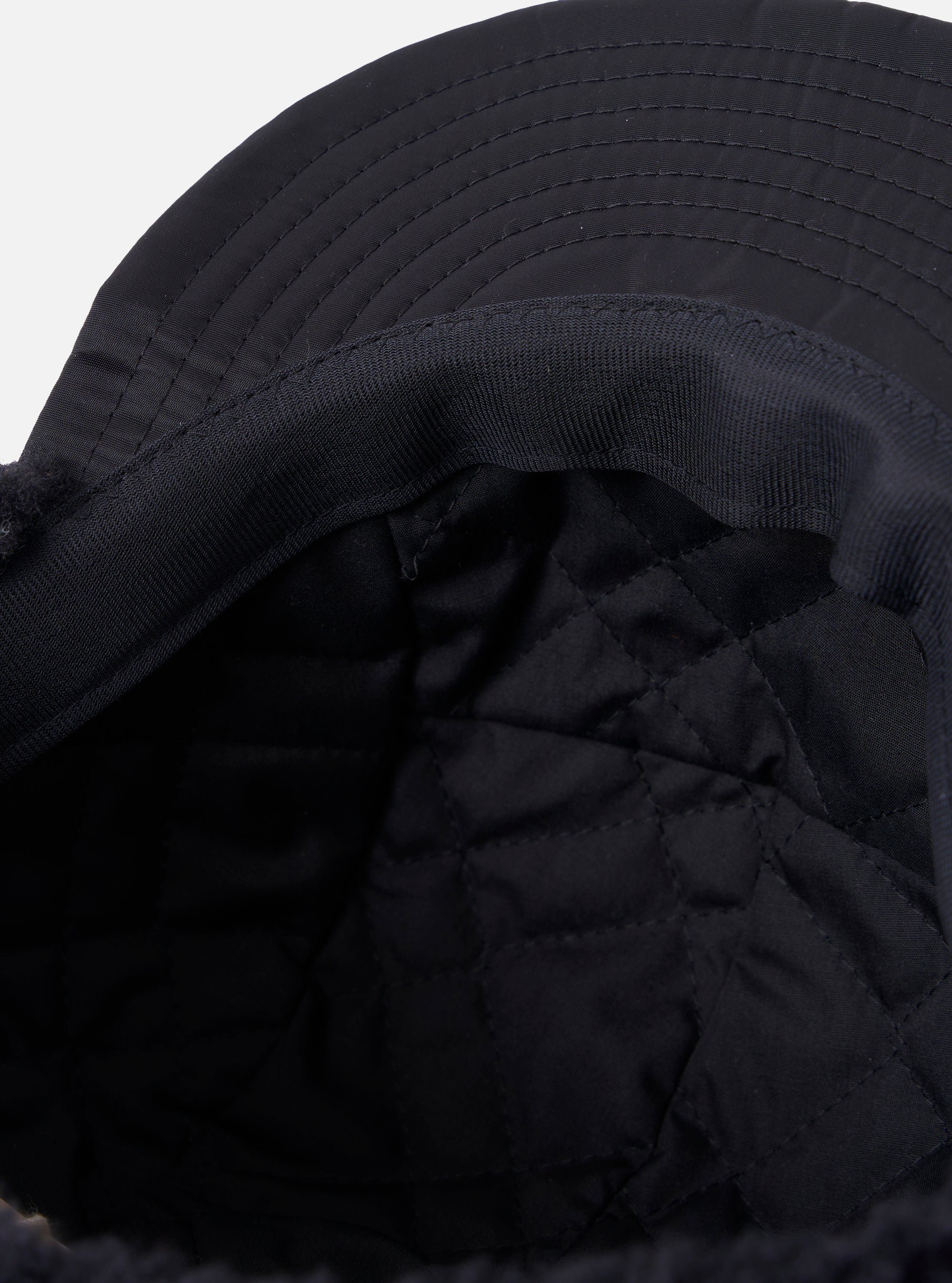 Close-up of the inside of a cableami® Black Military Nylon Twill Cap, showing the quilted lining and twill material. Shot on a white background.