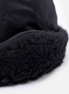 Close-up of the cableami® Black Military Nylon Twill Cap, showcasing the black nylon twill and plush black trim against a bright white background.