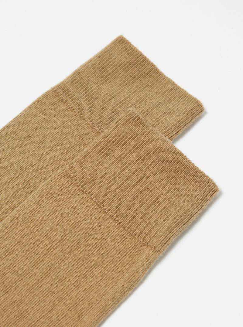 Close-up of Cumin Rib Knit Modal Sock on a white surface. The sock has a ribbed texture and a comfortable fit. The image is well-lit and focuses on the sock's details.