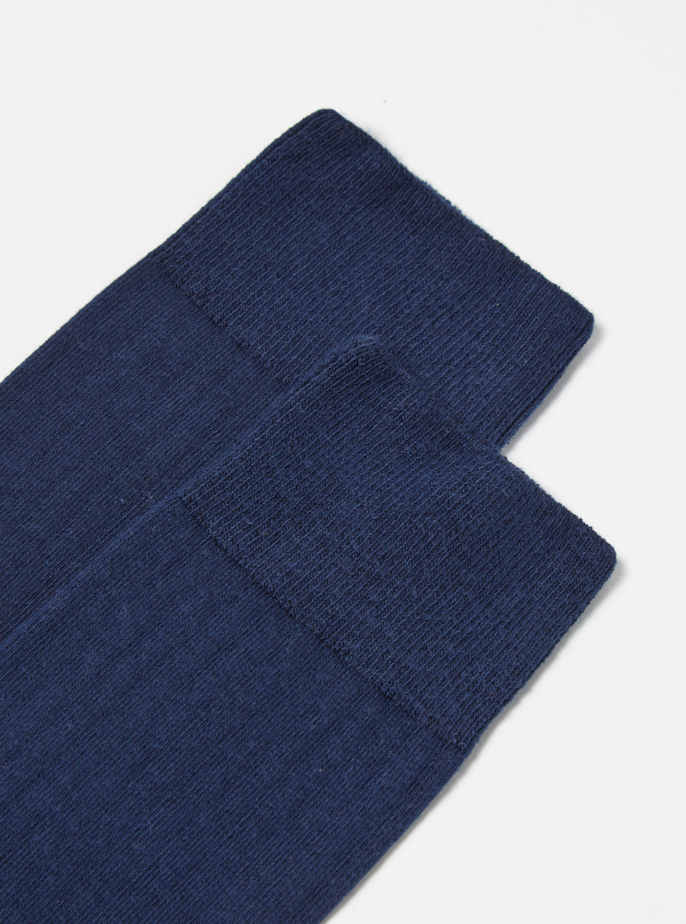 Close-up of a pair of Navy Rib Knit Modal Sock on a white surface. The socks are neatly stacked, showcasing their soft, ribbed texture and rich navy color.