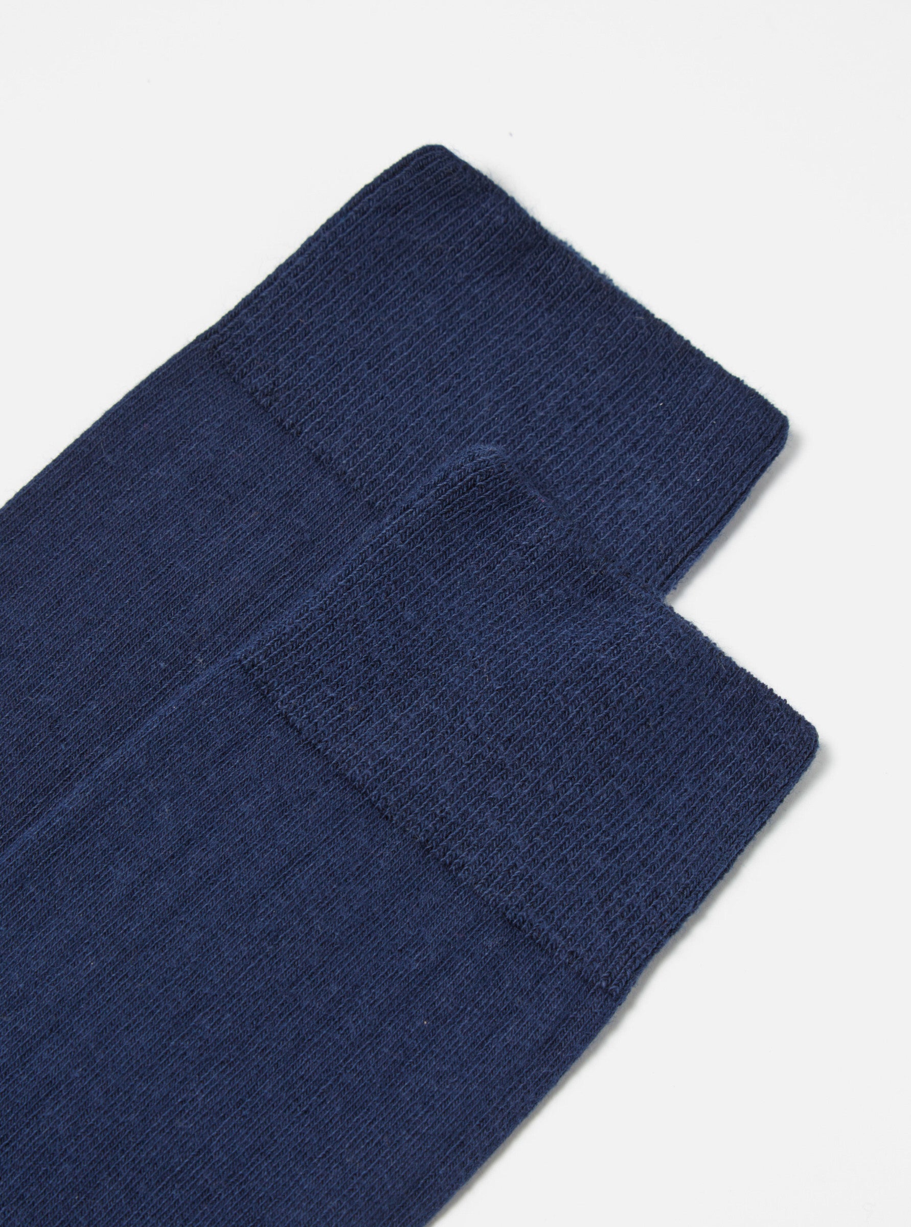 Close-up of a pair of Navy Rib Knit Modal Sock on a white surface. The socks are neatly stacked, showcasing their soft, ribbed texture and rich navy color.