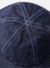 The cableami Indigo 10oz Denim Metro Hat is shown from a rear three-quarter angle as a flat lay against a plain white background. The image highlights the hat's rounded crown, downward-sloping brim, and the adjustable drawstring at the back. The indigo denim fabric features a visible slub texture and tonal stitching.