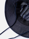 The cableami Indigo 10oz Denim Metro Hat is shown from the back as a flat lay against a plain white background. The image highlights the rounded crown construction, the stitching detail on the brim, and the adjustable toggle on the dark cord.