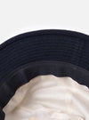 Close-up of the inside of a cableami® Navy Recycled Wool Army Hat, showing the navy wool exterior, dark band, and white lining. Shot on a white background.