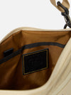 The master-piece x Universal Works Beige Canvas Sacoche is displayed from a rear angle as a flat lay against a plain white background. The image highlights the clean back panel of the bag, the adjustable black crossbody strap, and the silver-tone hardware. The beige canvas fabric has a visible, durable texture.