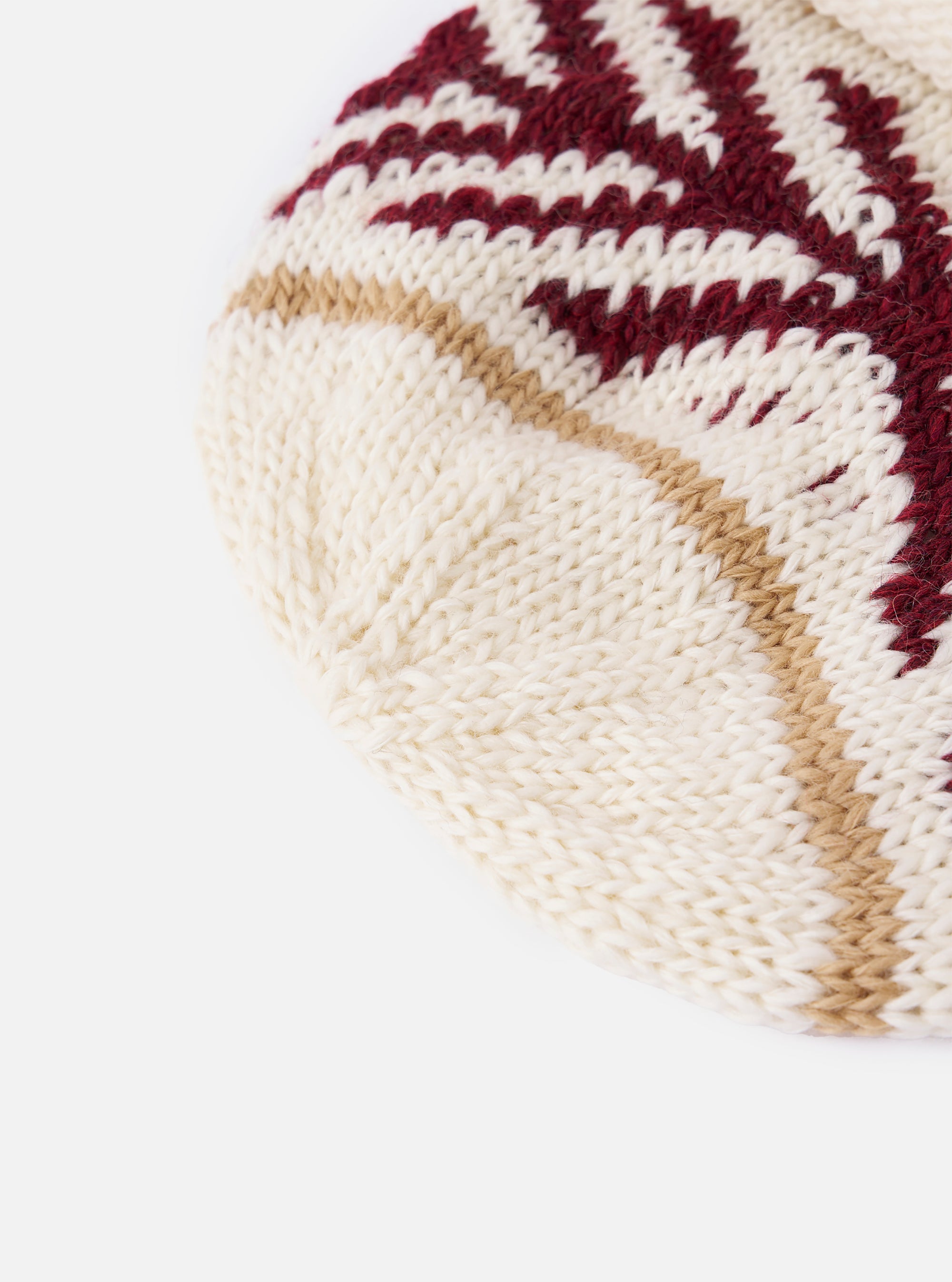 Close-up of a cableami® Ecru Wool Jacquard Watch Cap on a white background. The cap features ecru, burgundy, and tan jacquard patterns.