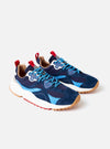 The Flower Mountain Navy/Azure Suede/Nylon Wave Man sneaker is shown from a side profile as a flat lay against a plain white background. The shoe features a navy blue suede and technical nylon upper with vibrant azure blue accents, signature nature-inspired perforated patterns, and a classic tape lacing system. The design is completed with a natural cork insole and a chunky, white notched-edge rubber sole.