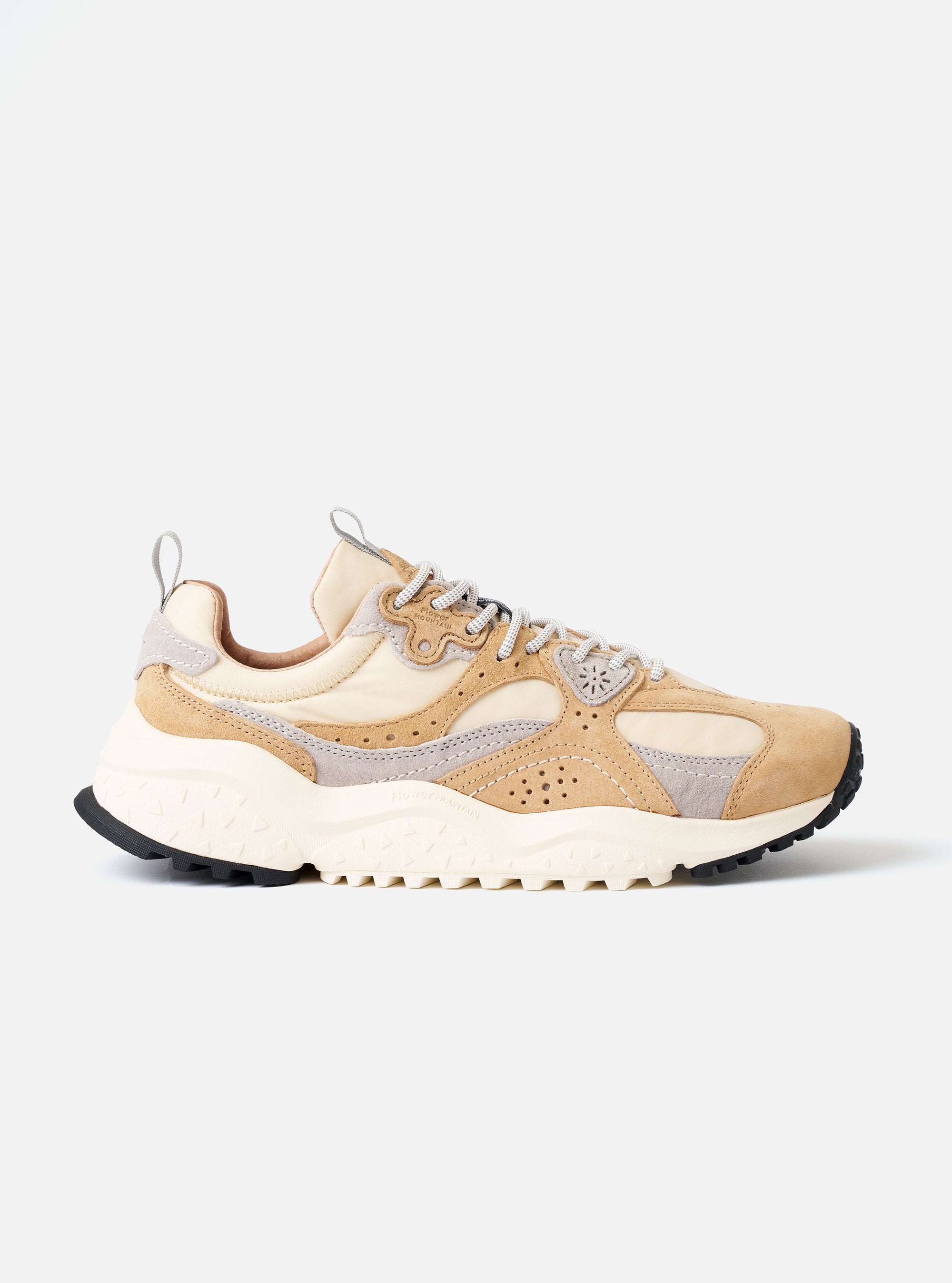 The Flower Mountain Beige/Cream/Light Grey Suede/Nylon Wave Uni is shown in a studio shot against a plain white background. The sneaker features a low-top silhouette with a beige technical ripstop fabric upper and light grey suede overlays with wavy, perforated edges. It has a classic lacing system with beige trekking laces and a webbing pull tab at the heel. The shoe is finished with a natural cork insole and a signature notched rubber sole in a two-tone light grey and gum finish.