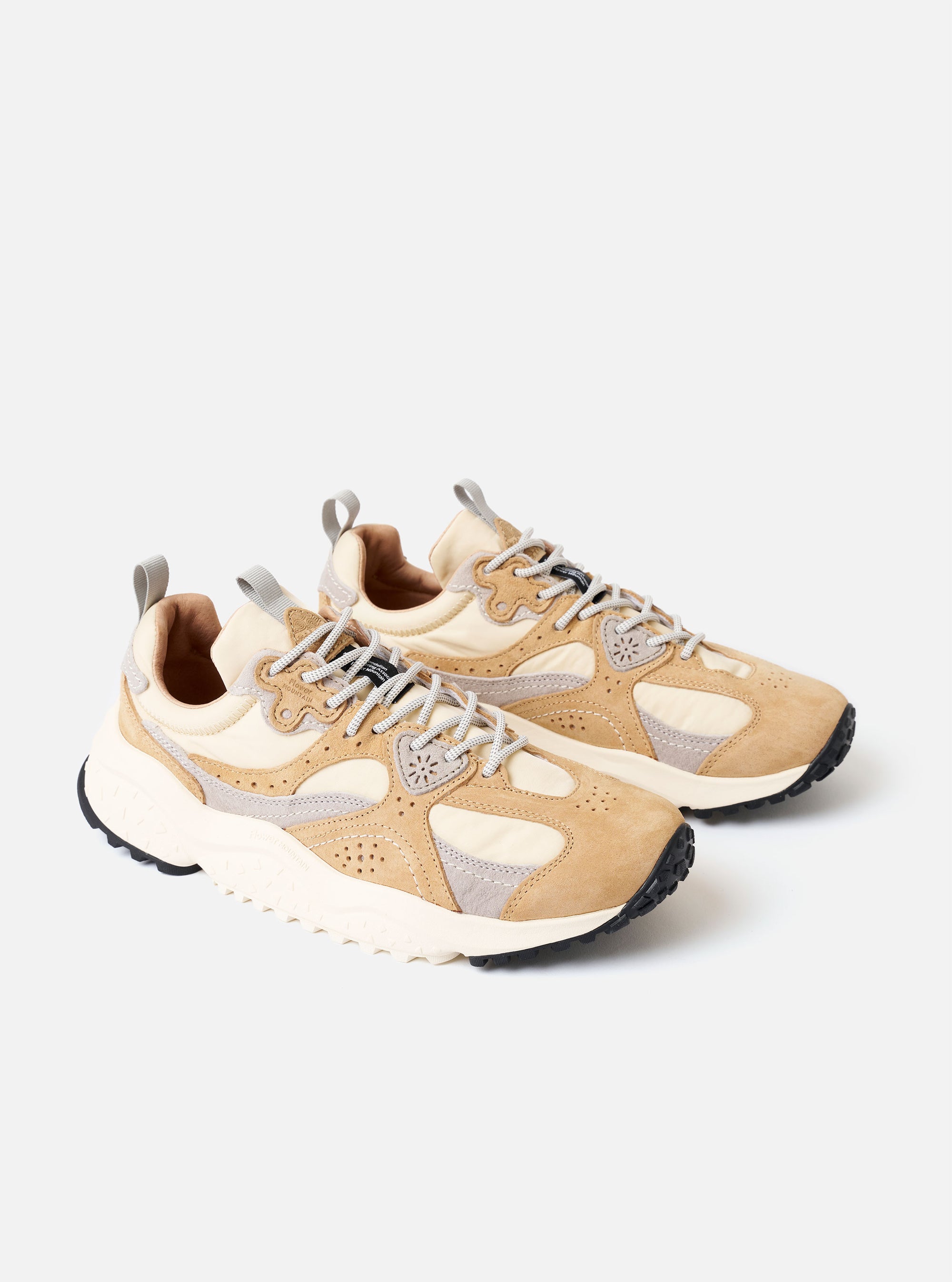 The Flower Mountain Beige/Cream/Light Grey Suede/Nylon Wave Uni sneaker is shown from a side profile against a plain white background. The sneaker features an overlapping construction with panels of light grey and cream suede layered over a beige technical nylon upper. It is detailed with round trekking laces and distinctive flower-shaped metal eyelets. The shoe sits on a chunky, off-white rubber sole with a signature notched tread.