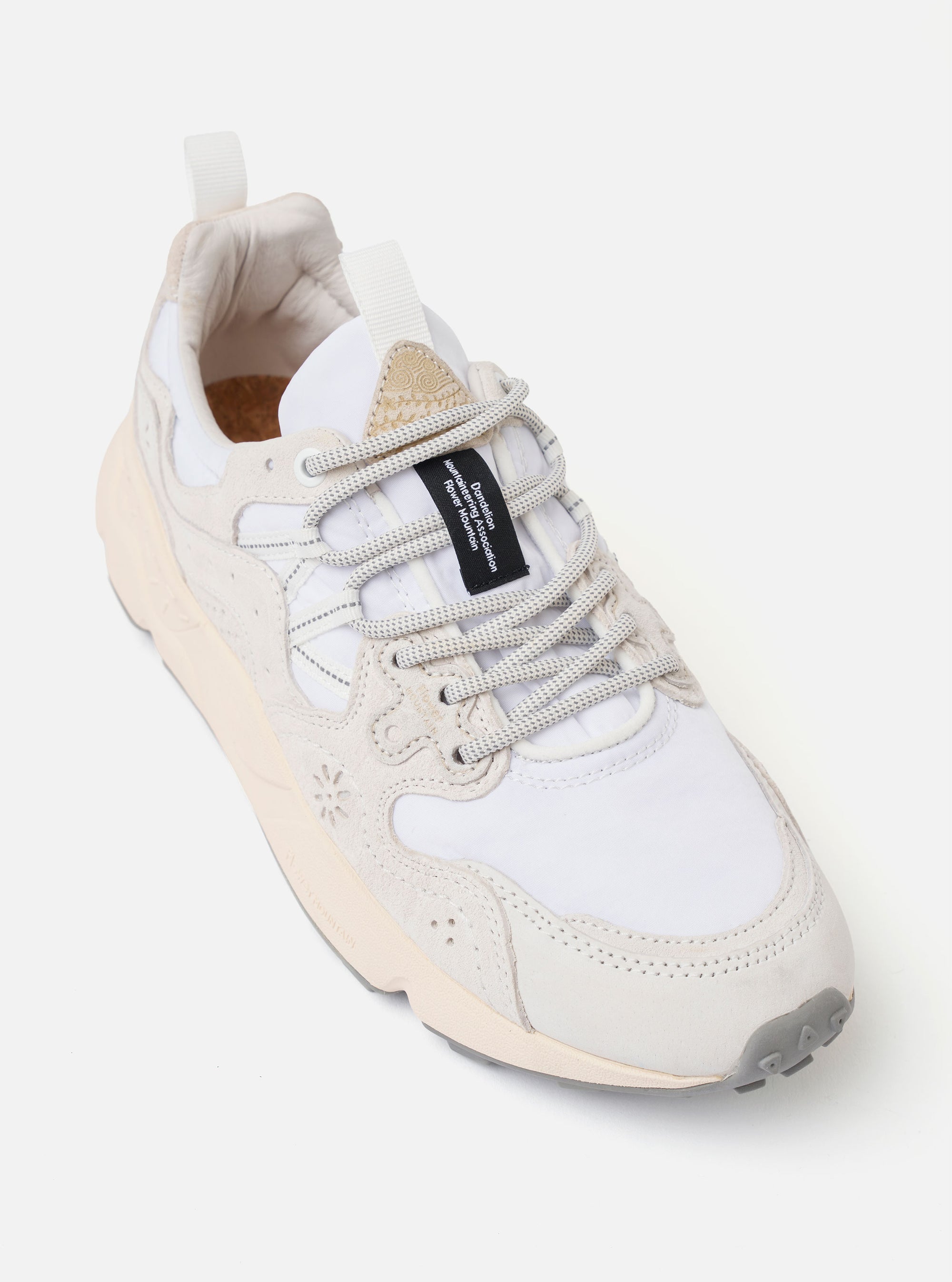 The Flower Mountain White/Off White Suede/Nylon Yamano 3 Uni sneaker is shown from a side profile as a flat lay against a plain white background. The design features a multi-layered upper with white nylon and off-white suede overlays, distinctive flower-shaped perforations on the side, and cream-colored trekking laces with reinforced leather eyelets. The shoe is finished with a chunky, toothed rubber sole in a tonal off-white shade.