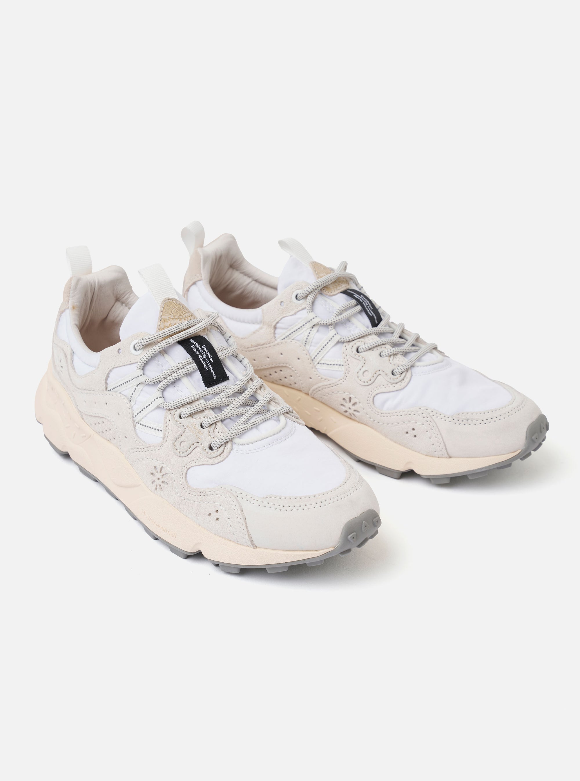 The Flower Mountain White/Off White Suede/Nylon Yamano 3 Uni is shown from a side angle against a plain white background. The sneaker features a layered upper of off-white suede and white technical nylon with unique perforated patterns. It is designed with trekking-style laces, leather eyelets, and a signature notched rubber sole.