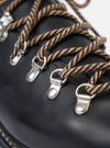 The Paraboot Black Leather Clusaz Jannu is shown as a studio shot against a plain white background. The low-top hiking-style shoe is crafted from smooth black leather and features a prominent Norwegian welt with visible stitching connecting the upper to the thick rubber lug sole. The design includes a rounded toe, D-ring metal eyelets with rope laces, and a wrap-over tongue construction.