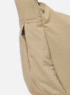 The master-piece x Universal Works Beige Medium Canvas Shoulder Bag is shown from the back as a flat lay against a plain white background. The image highlights the adjustable shoulder strap, a large rear compartment with a snap-button closure, and the durable beige canvas construction.