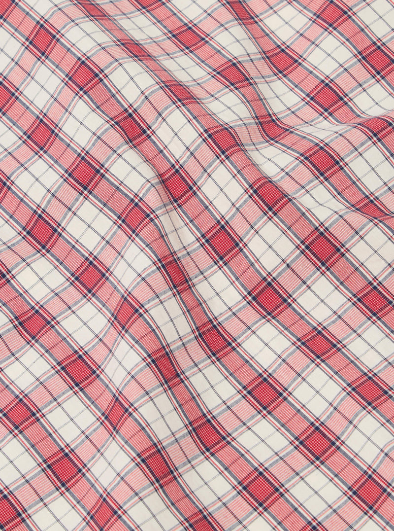Close-up of the Red Cotton Check Pyjama Pant fabric. The red and blue plaid cotton is softly draped on a flat surface.