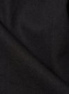 Close-up of the Black Twill Duke Pant fabric. The dark, textured twill is neatly folded on a plain surface, highlighting the material's weave.