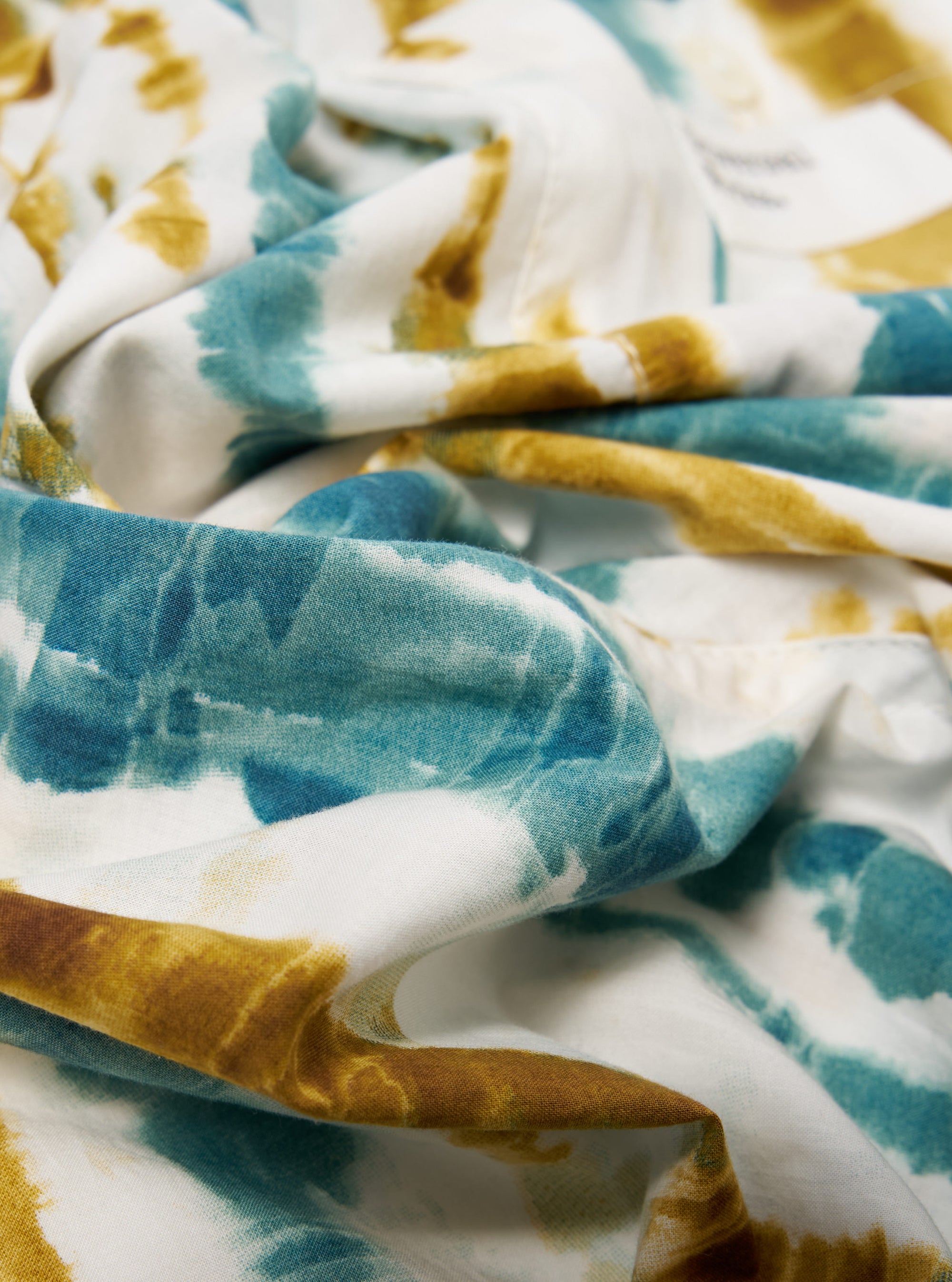 Close-up of the Ecru Paint Print Boxer Short. The fabric is white with blue and brown paint print. The shot is a macro studio shot.