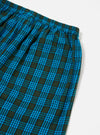 Close-up of the Blue Brushed Check Pyjama Pant on a white surface. The brushed cotton fabric features a blue and dark green check pattern. Elasticated waist detail visible.