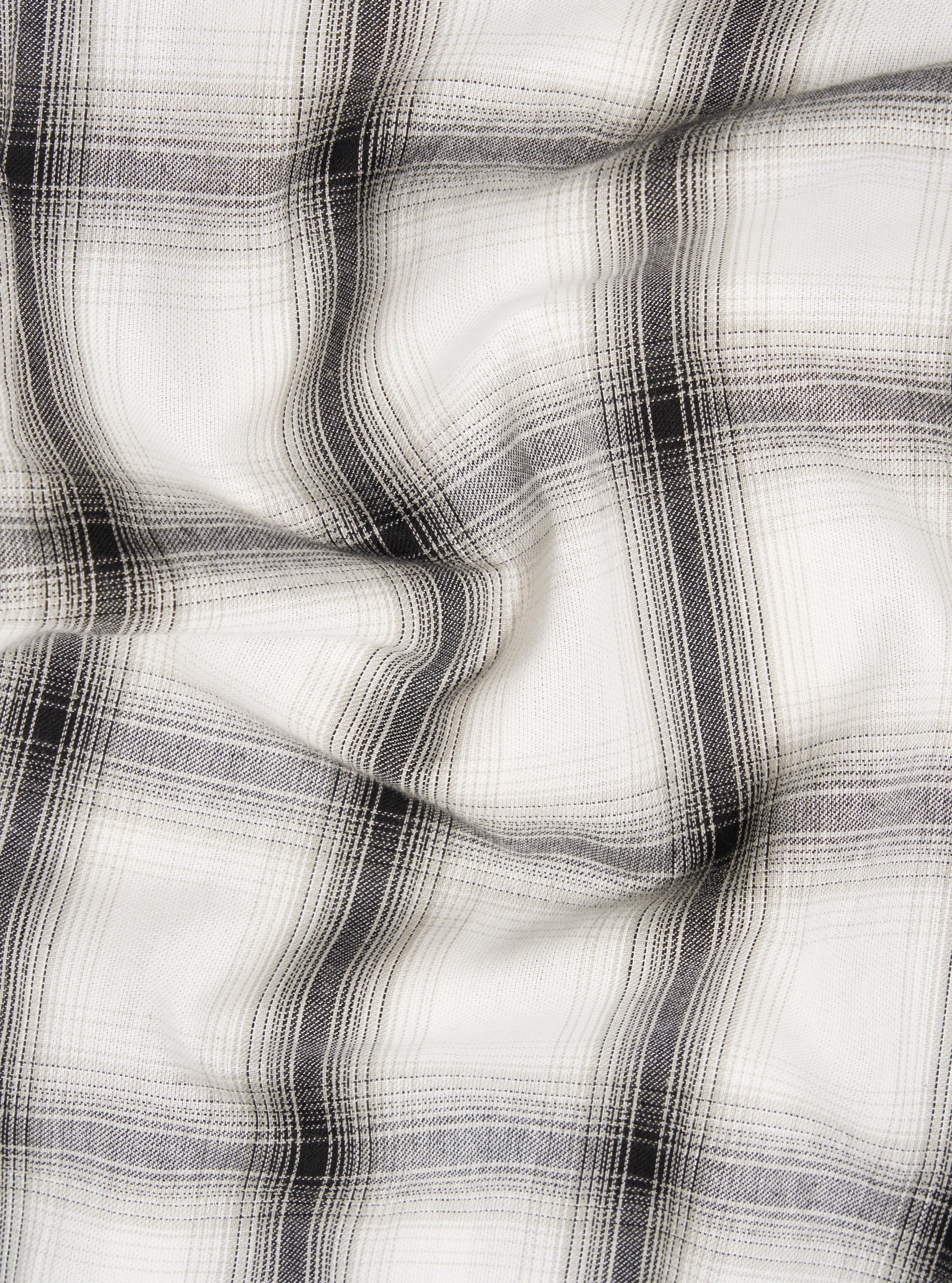 Close-up of the Ecru Shadow Check Pyjama Pant fabric. The soft, neutral-toned material features a subtle shadow check pattern, displayed on a flat surface with gentle folds.