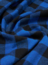 Close-up of the Blue Brushed Bold Gingham Pyjama Pant fabric. The material is a soft, brushed cotton in a blue and black gingham pattern, draped on a flat surface.