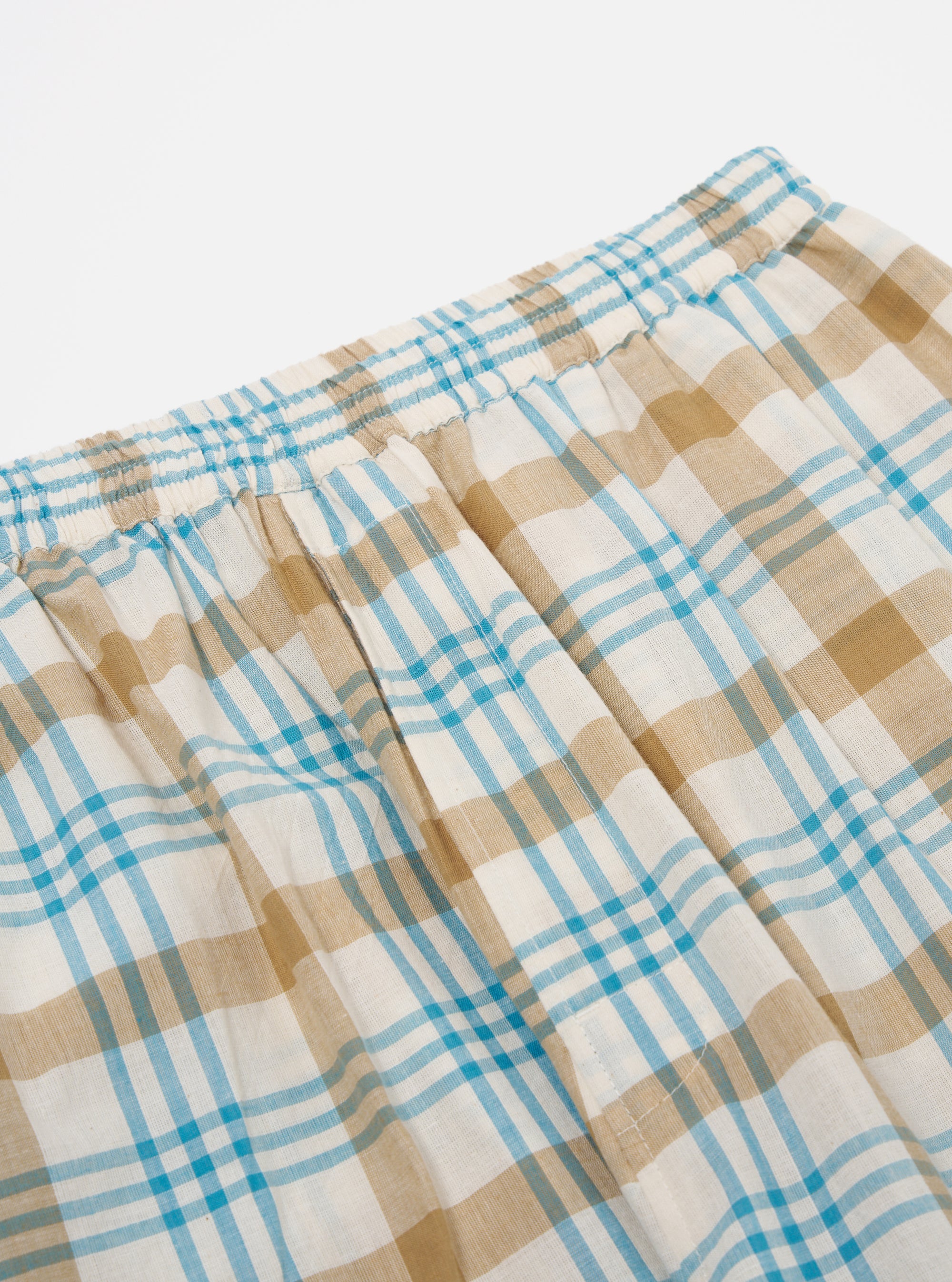 Close-up of the Ecru Madras Check Pyjama Pant on a white background. The pant features a blue, ecru, and tan plaid pattern with an elastic waistband.