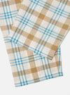 Close-up of the Ecru Madras Check Pyjama Pant on a white surface. The cotton fabric features a blue, tan, and white plaid pattern.