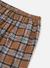 Close-up of the Brown Ikat Twill Check Long Pyjama Set. Brown, black, white and red check pattern. Elasticated waist. Shot on a white background.
