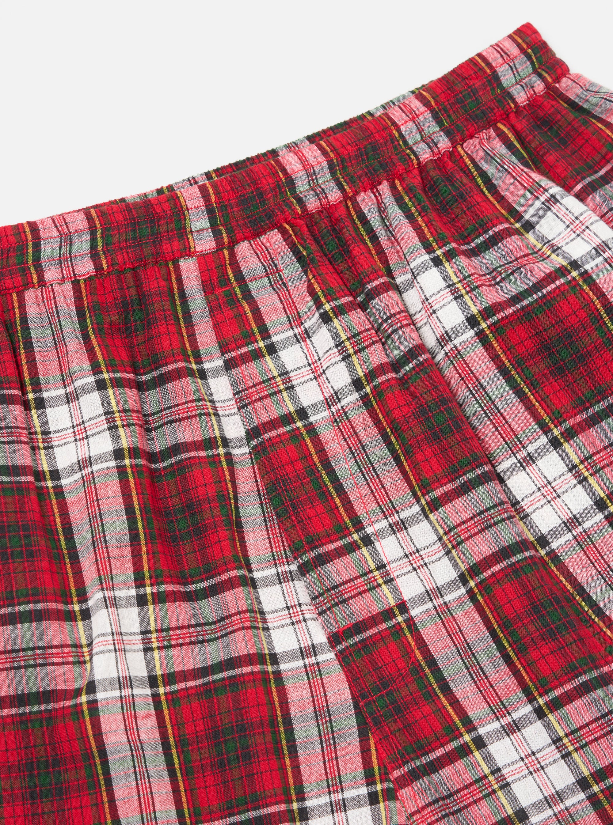 Close-up of the Red Madras Check Short Pyjama Set. Red, white, and green plaid pattern. Elastic waistband. Shot on a white background.