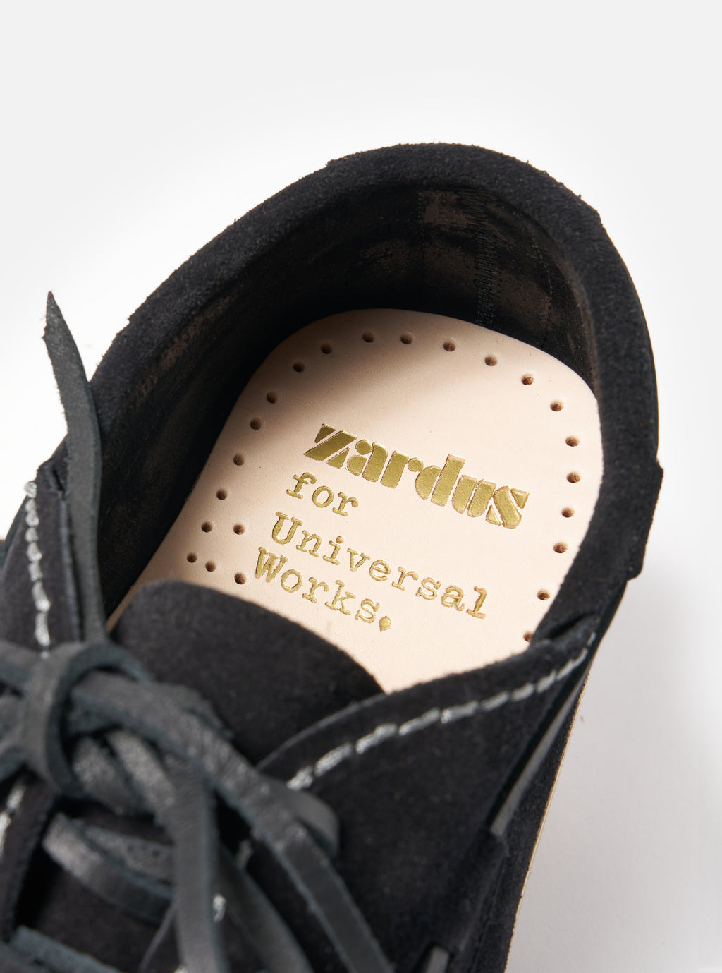 Close-up of the Zardus for Universal Works Black Suede Oliver shoe on a white background, showing the insole with gold lettering.