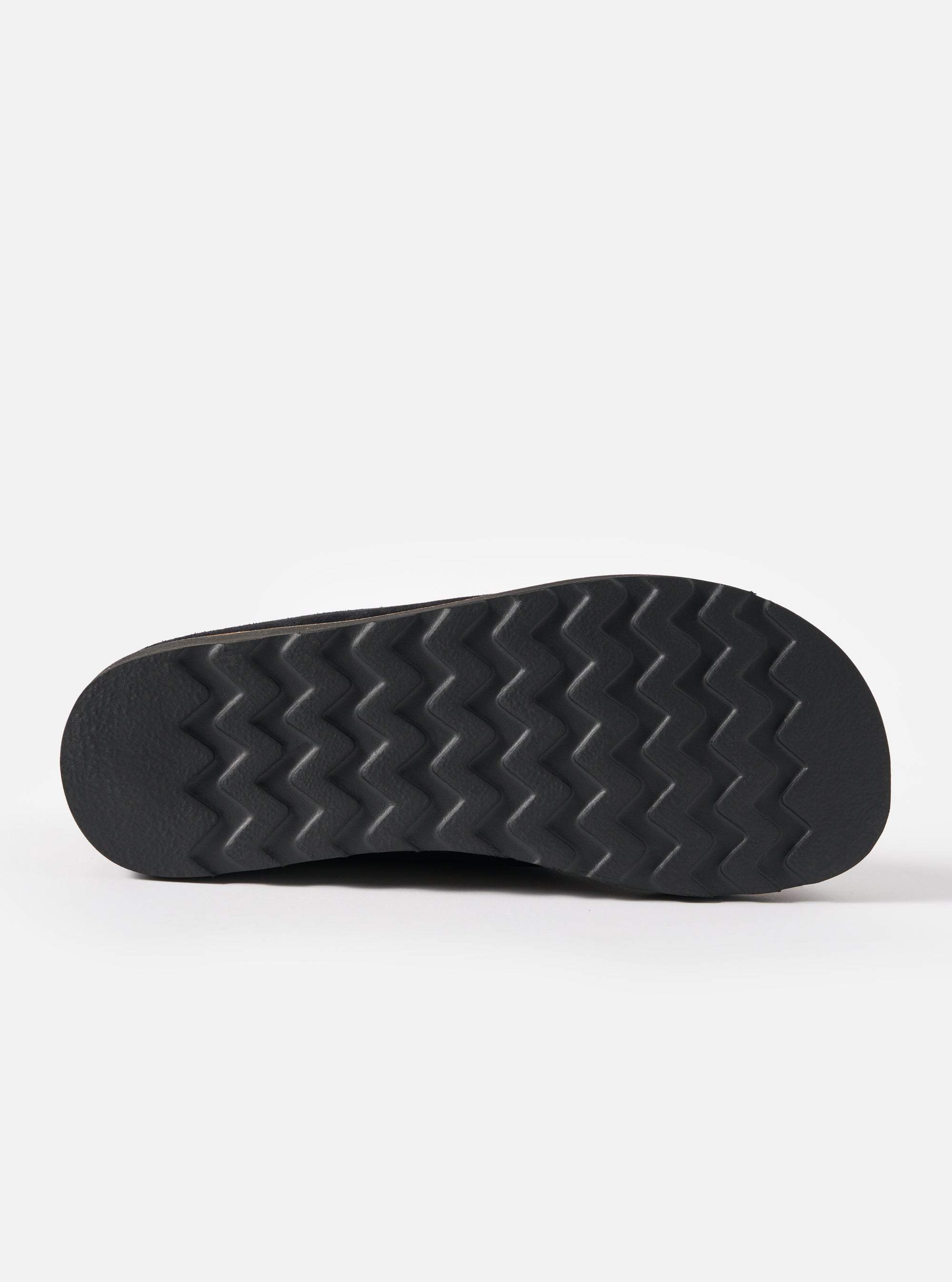 Close-up of the sole of the Zardus for Universal Works Black Suede Oliver sandal. The black rubber sole has a zig-zag pattern. Shot on a white background.
