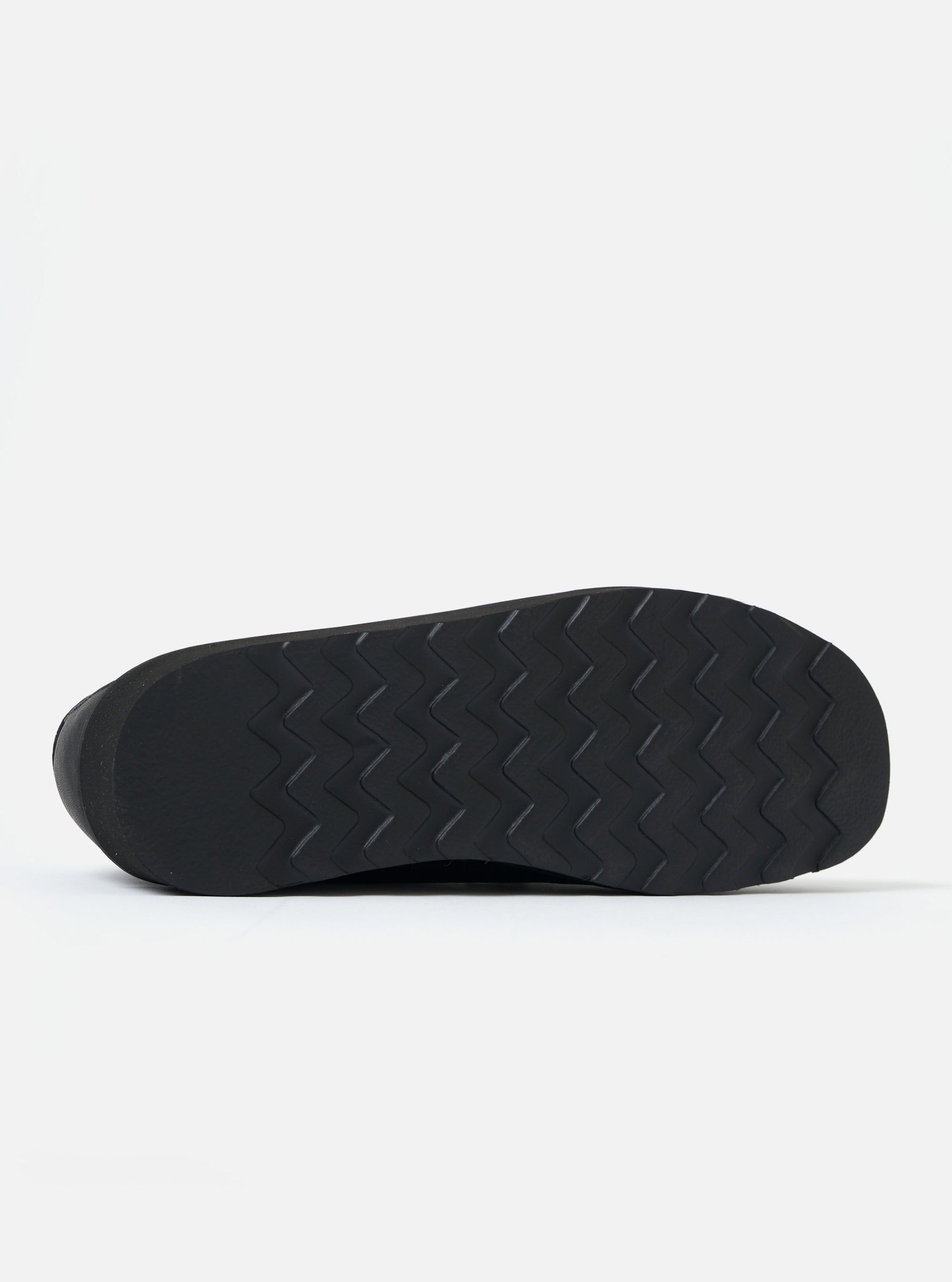 Close-up of the sole of the Zardus for Universal Works Black Leather Reggie Loafer, showing the textured black rubber against a white background.