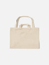 Studio shot of an Ecru Canvas Market Tote on a white background. The tote is a light beige color and made of canvas material. It has two handles and a rectangular shape.