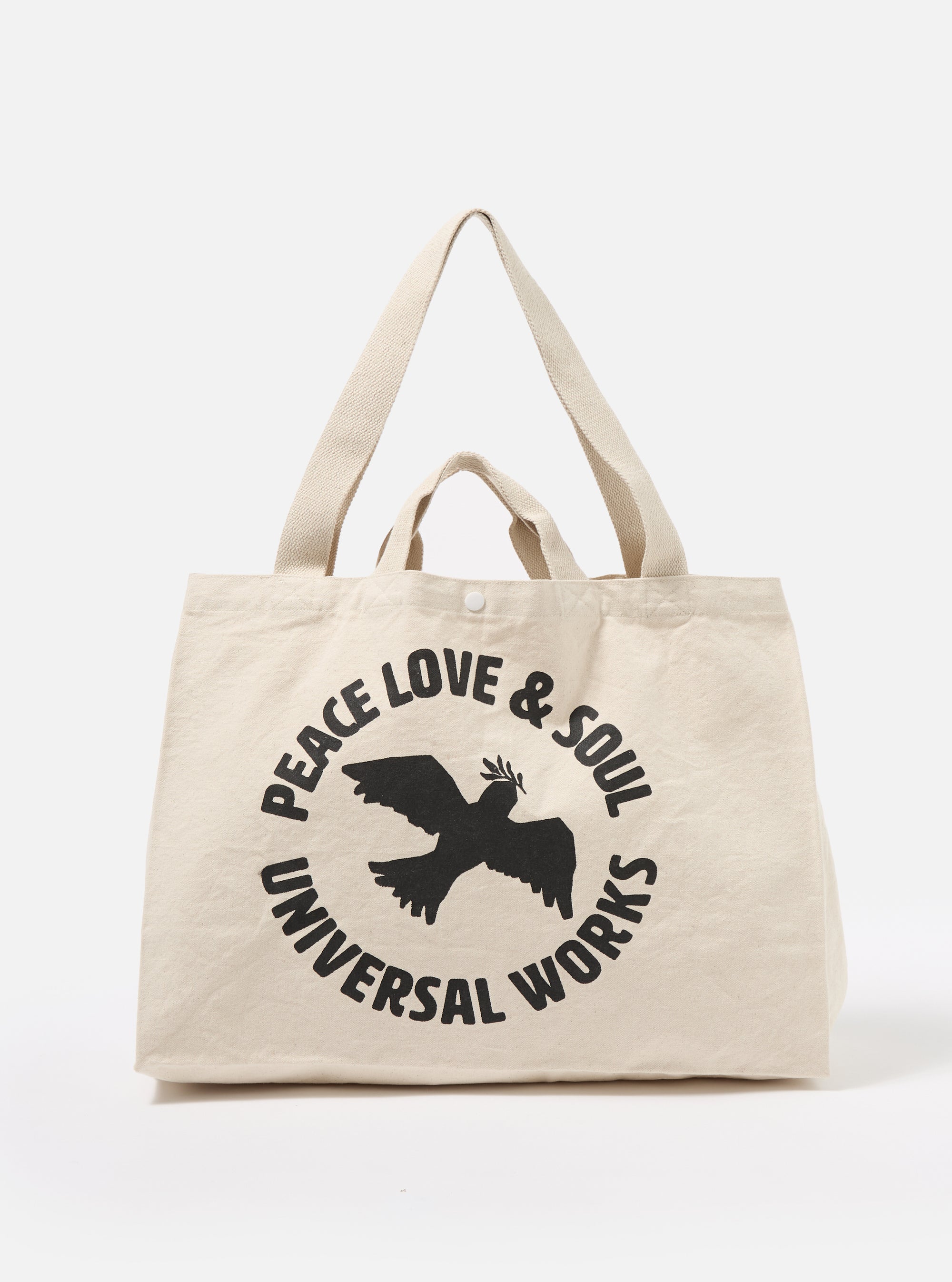 The Ecru Canvas Market Tote bag. The bag is ecru-colored canvas with black text and a bird graphic. The background is a plain white studio backdrop.
