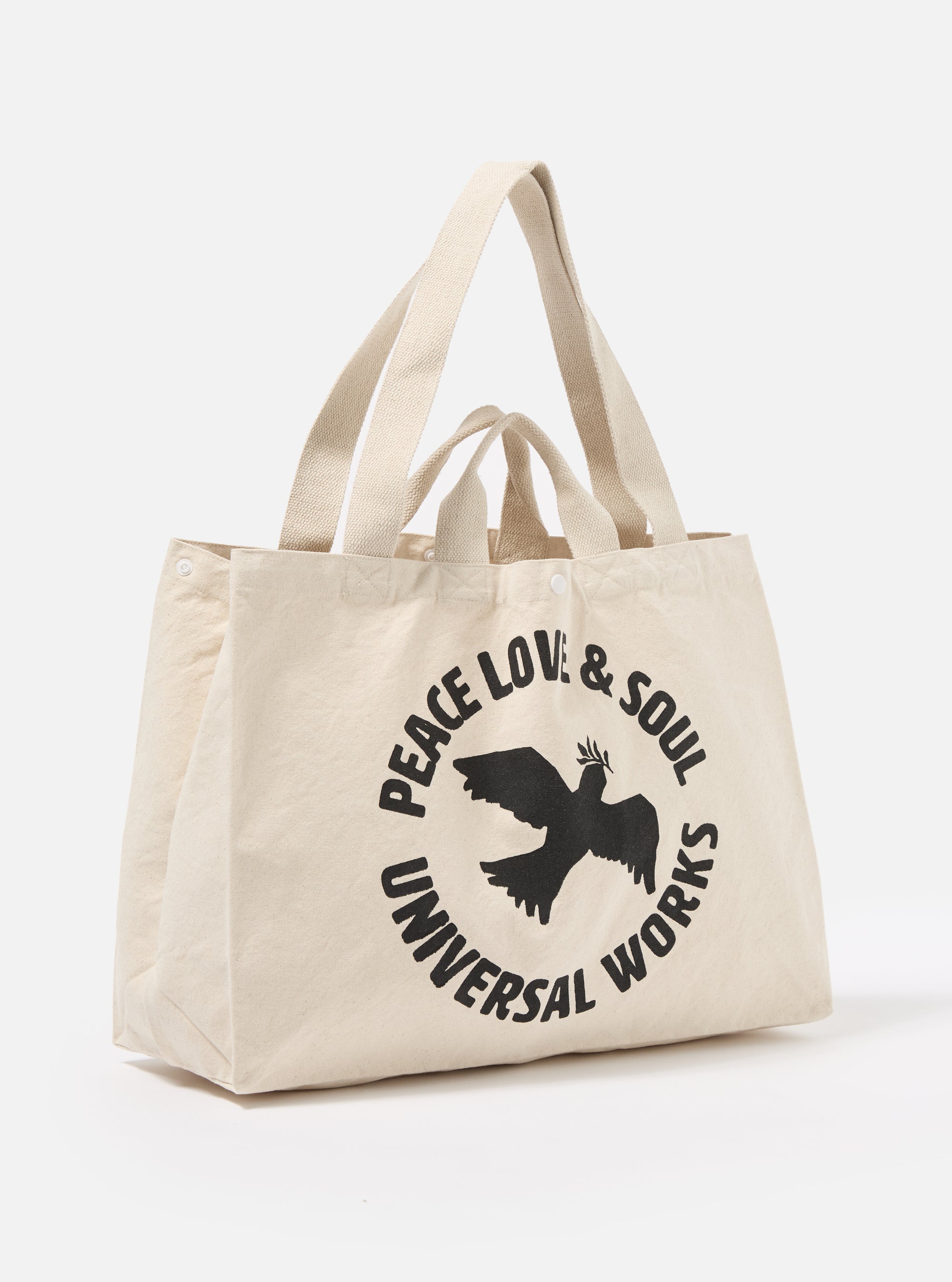 Studio shot of an Ecru Canvas Market Tote. The bag is ecru-colored canvas with black graphic print. The background is a plain white.