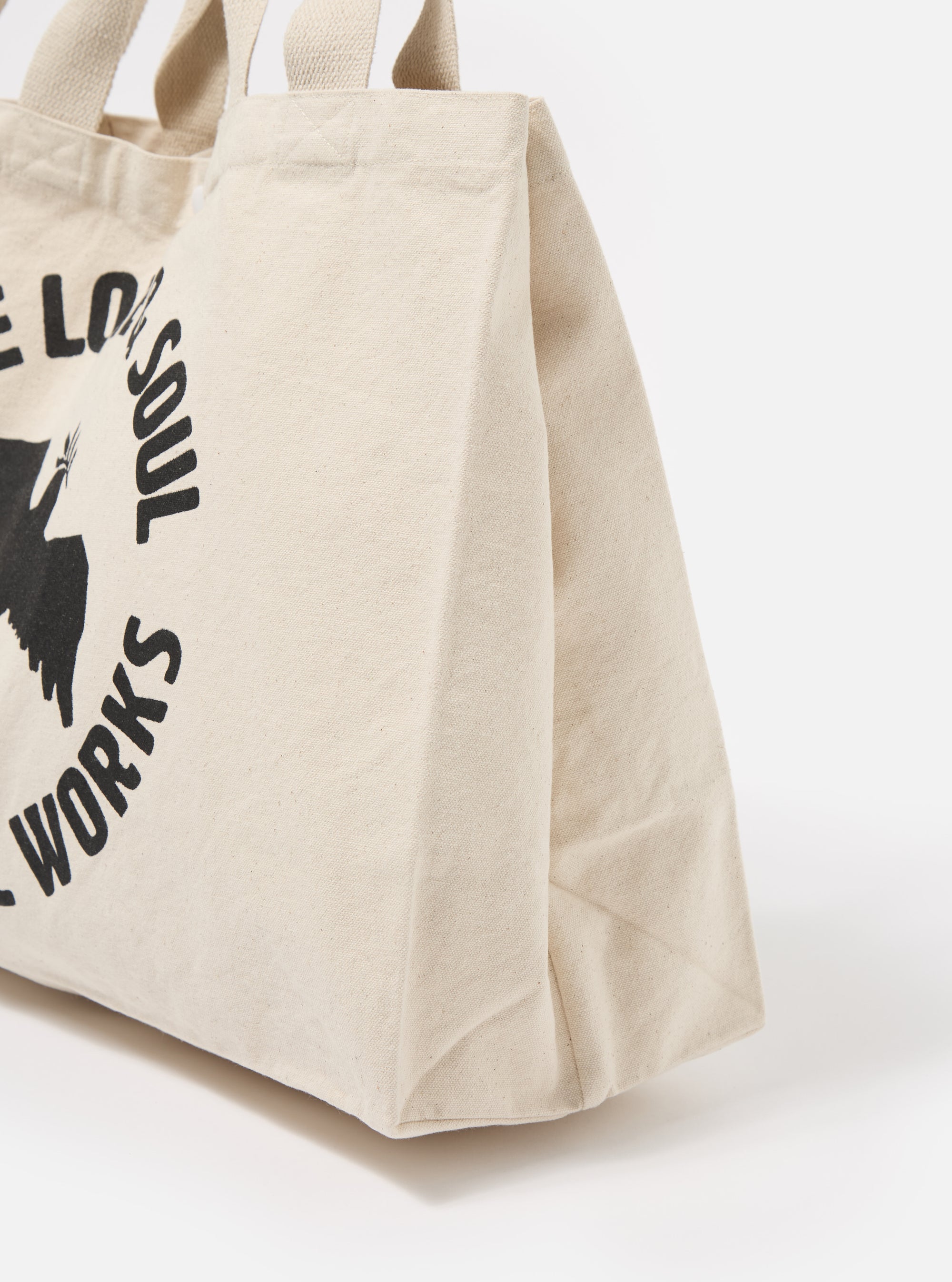 Close-up of an Ecru Canvas Market Tote against a white background. The tote features black printed graphics. Made of durable canvas with sturdy handles.