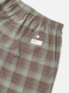 Close-up of Multi Check 3 Pack Boxer Short on a white surface. Features a brown, green, and blue plaid pattern, elastic waistband, and a back pocket with a white tag.