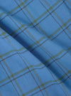 Close-up of blue plaid fabric, part of the Multi PJ Plaid 3 Pack Boxer Short collection. Soft cotton material with green and black lines. Shot on a flat surface.
