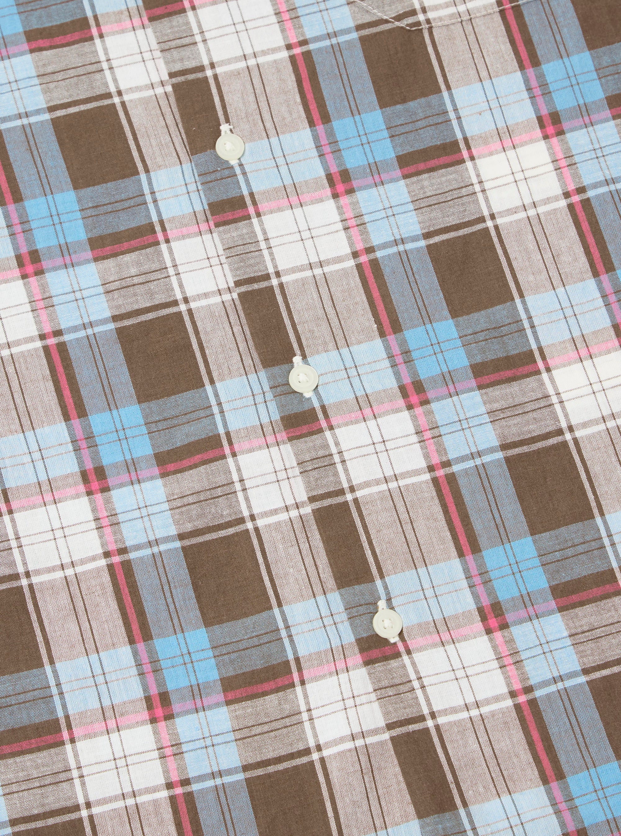 Close-up of the Blue/Brown Check 3 Long Pyjama Set fabric. Features a blue, brown, pink, and white plaid pattern with button details. The fabric is neatly arranged on a flat surface.