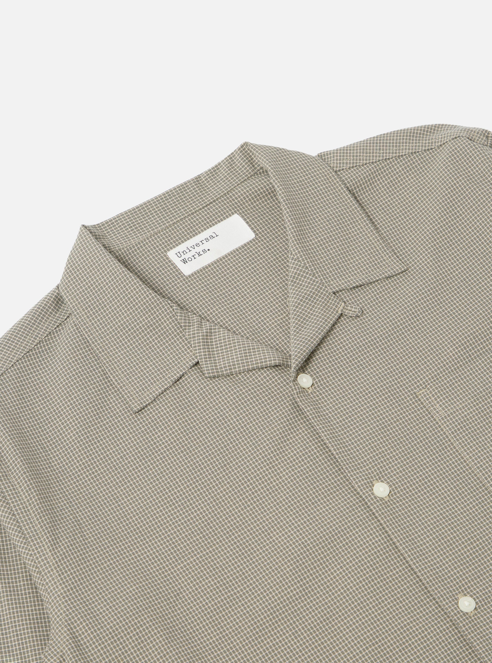 Close-up of the Green Tiny Check Long Pyjama Set top. The shirt is neatly folded on a white surface, showcasing its tiny green check pattern and relaxed fit.