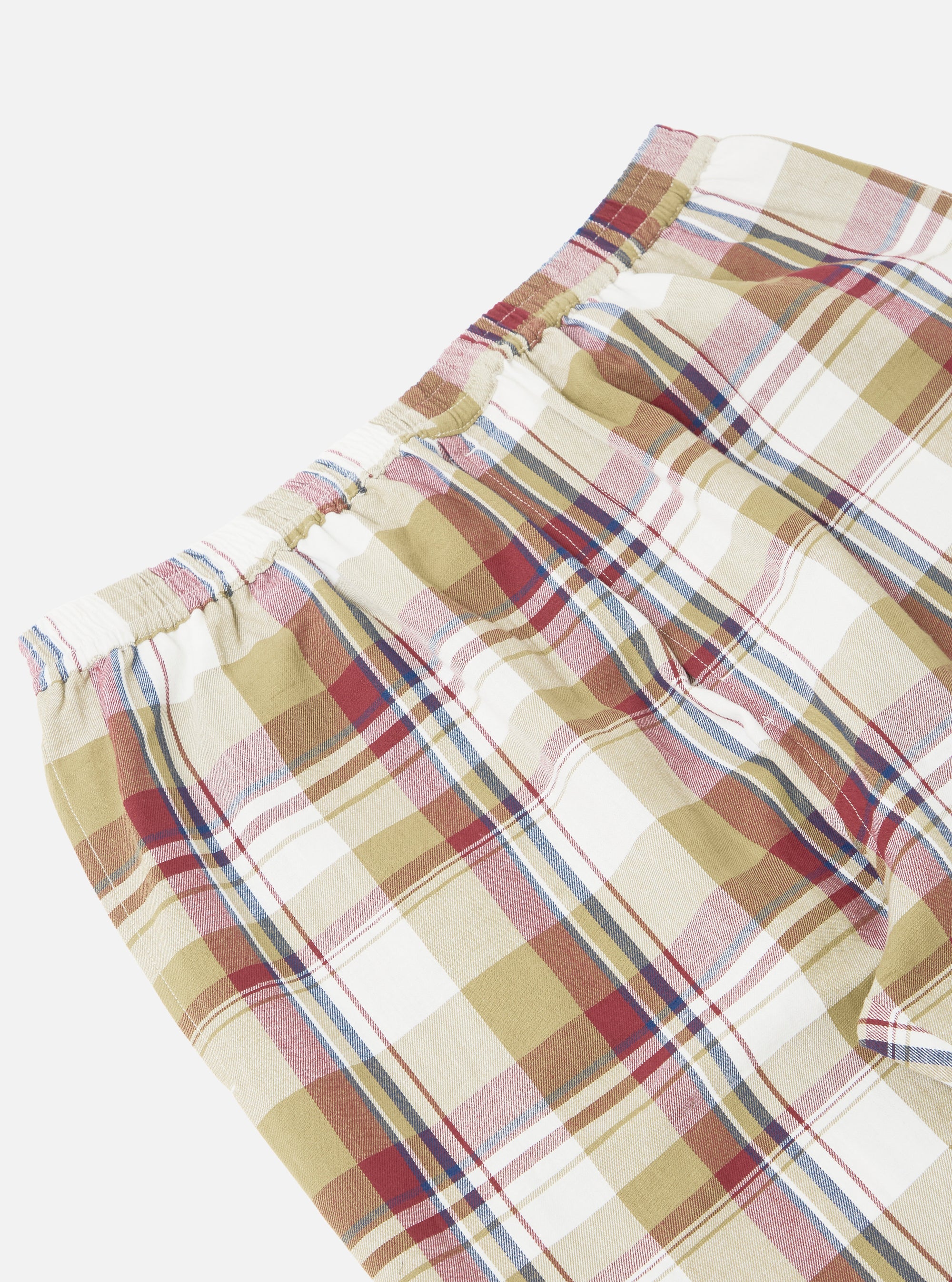Close-up of the Red/Brown Kip Check Long Pyjama Set. The fabric is a soft, brushed cotton with a red, brown, and white check pattern. Elasticated waist. Shot on a white background.