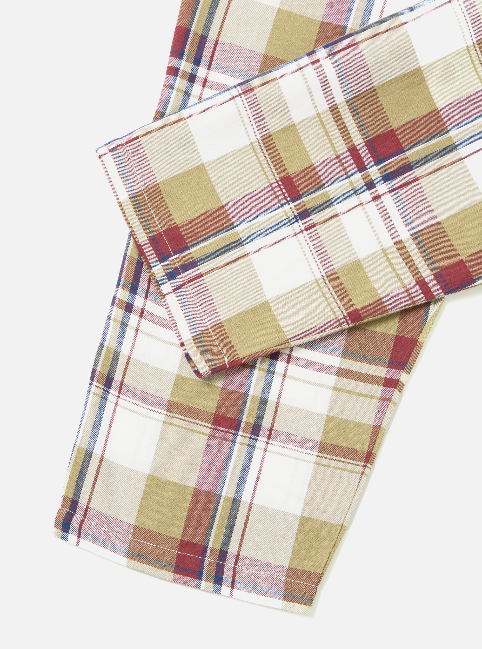 Close-up of the Red/Brown Kip Check Long Pyjama Set. The fabric features a red, brown, and blue check pattern on a white background. Shot on a white surface.