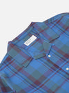 Close-up of the Blue Kip Check Long Pyjama Set top on a white background. The blue, green, and maroon plaid shirt has a collar and white buttons.