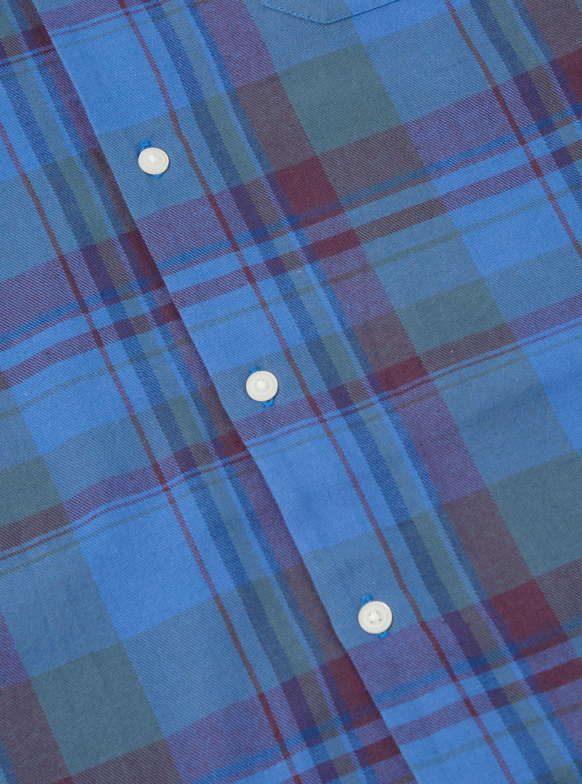 Close-up of the Blue Kip Check Long Pyjama Set. Features a blue, green, and maroon plaid pattern with white buttons. The fabric is soft and comfortable.