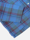 Close-up of the Blue Kip Check Long Pyjama Set on a white surface. The fabric is a blue, green, and burgundy plaid. 