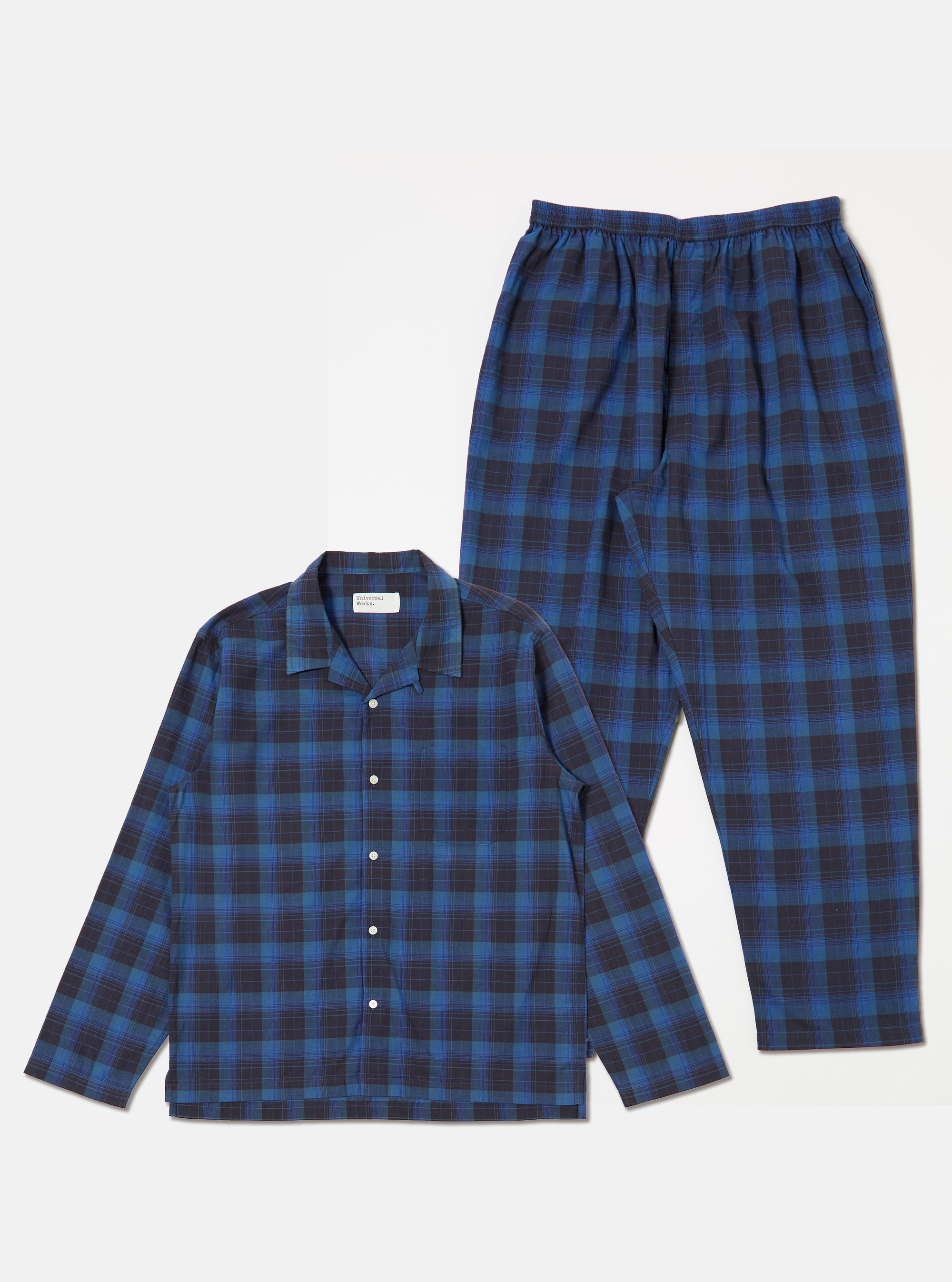 The Navy/Blue Check Long Pyjama Set is laid out on a white background. The set features a blue and navy check pattern. The top is a button-down shirt with long sleeves and a collar.