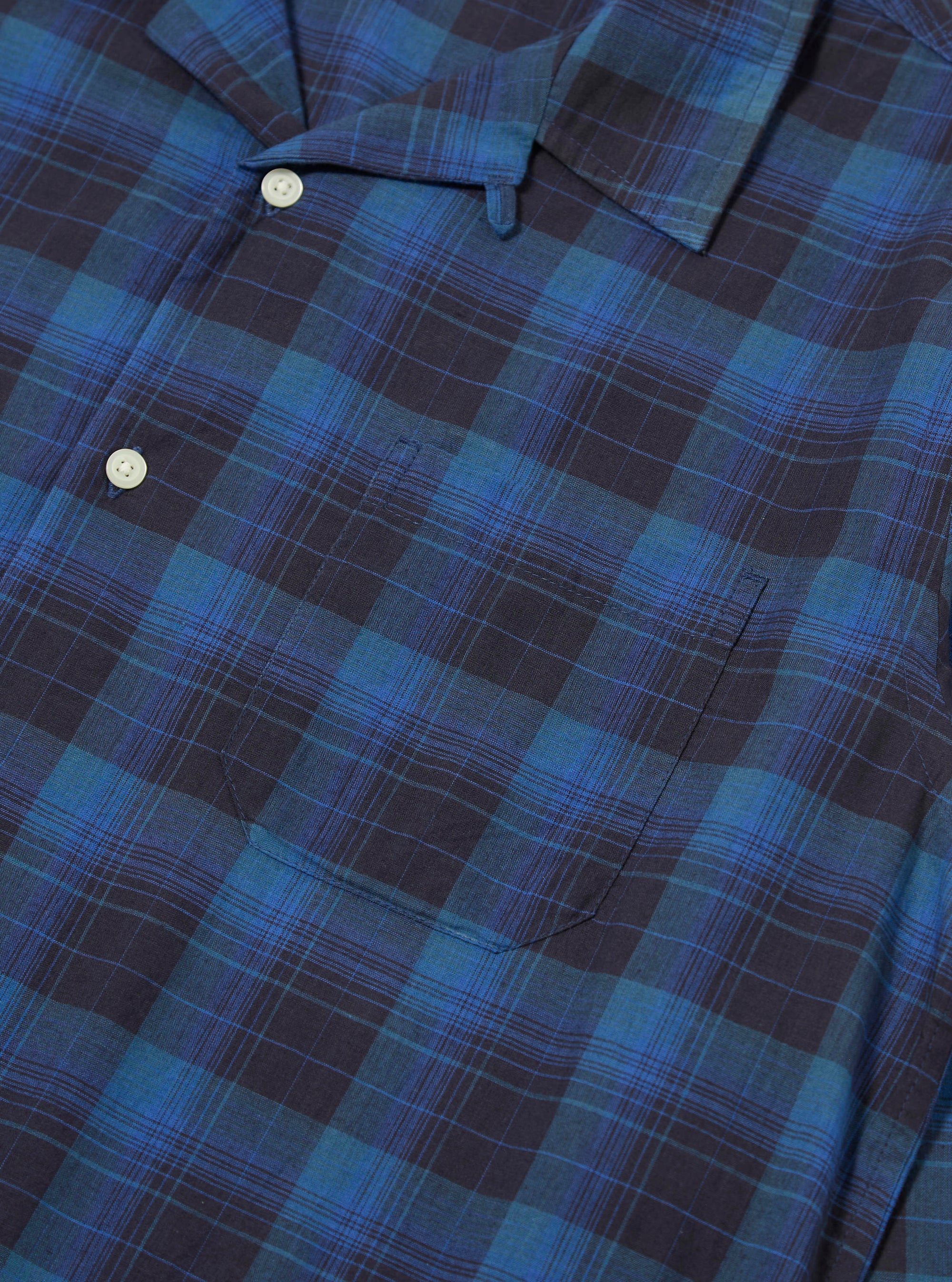 Close-up of the Navy/Blue Check Long Pyjama Set top. The blue and navy check pattern is visible, along with the shirt pocket and buttons. The background is a plain surface.