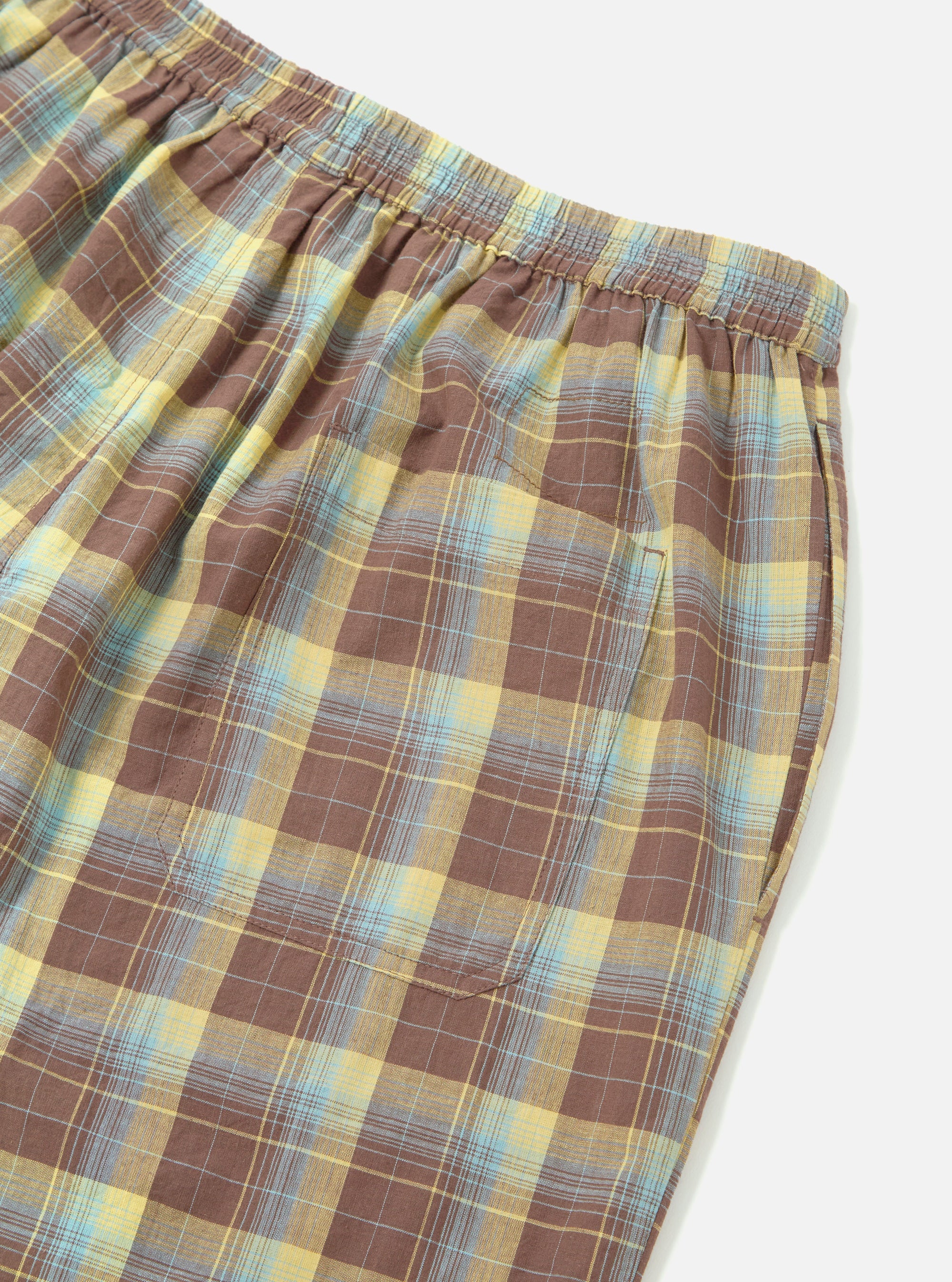 Close-up of the Yellow/Brown Check Short Pyjama Set. Features a yellow, brown, and blue plaid pattern. The shorts have an elastic waistband and a pocket. Shot on a white background.