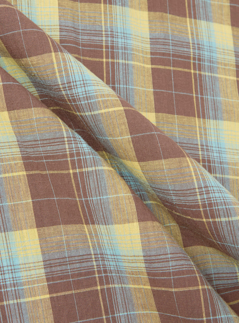 Close-up of the Yellow/Brown Check Short Pyjama Set fabric. The soft, brushed cotton features a yellow, brown, and blue plaid pattern with gentle folds.