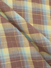 Close-up of the Yellow/Brown Check Short Pyjama Set fabric. The soft, brushed cotton features a yellow, brown, and blue plaid pattern with gentle folds.