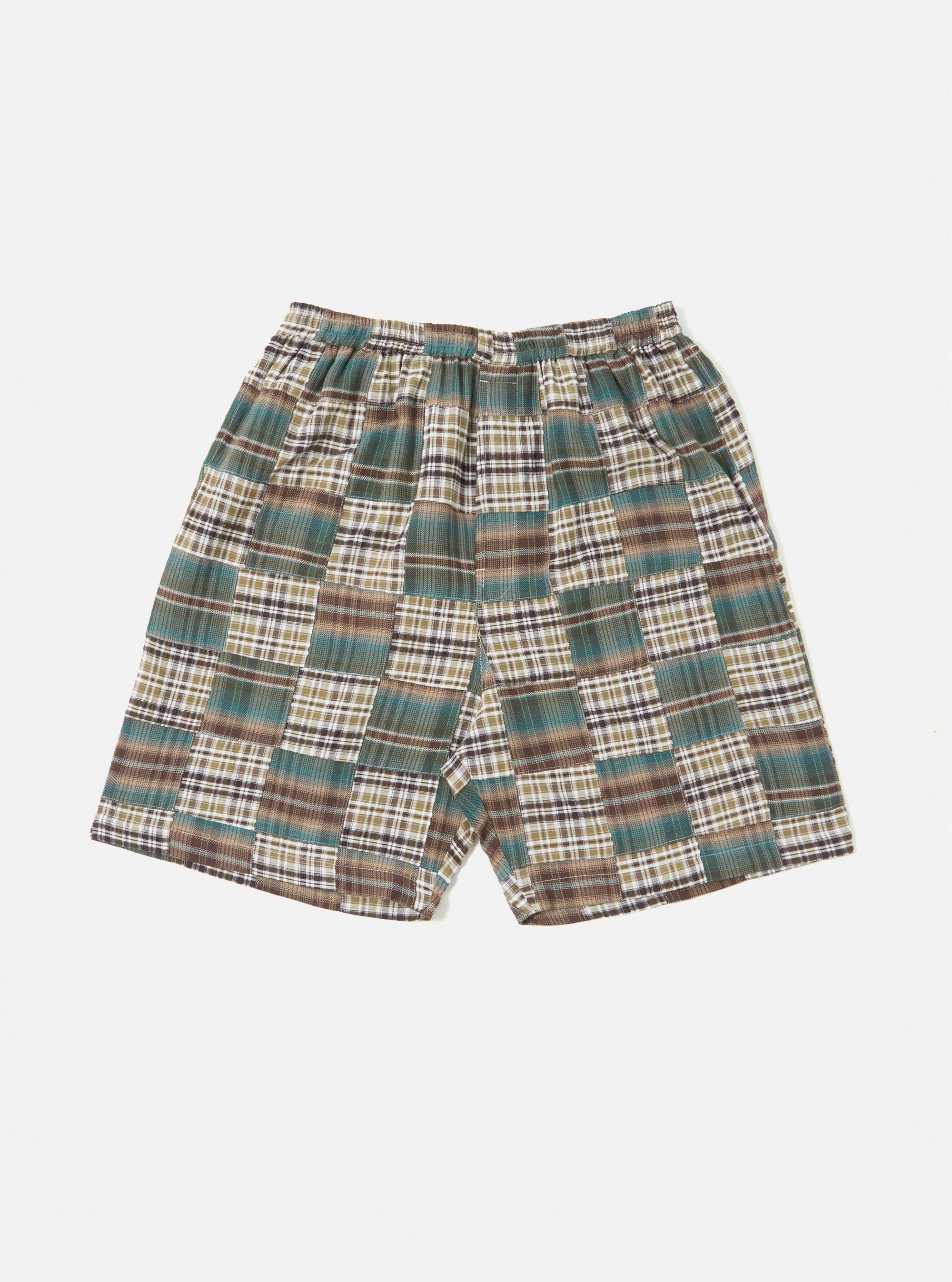 The Green Patchwork Madras Pyjama Short, featuring a green, brown, and white plaid pattern, is laid on a white background. The shorts have an elastic waistband.